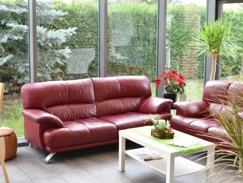 Sitzbereich mit roten Sofas und Pflanzen in Haus Anna